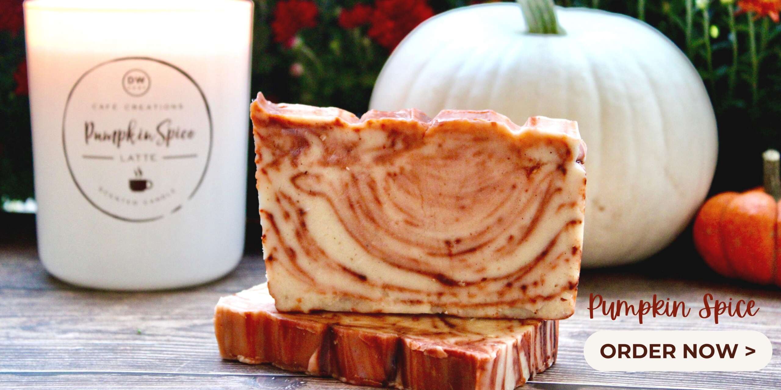 Pumpkin Spice Fudge with Pumpkin spice candle and white and orange pumpkins in the back