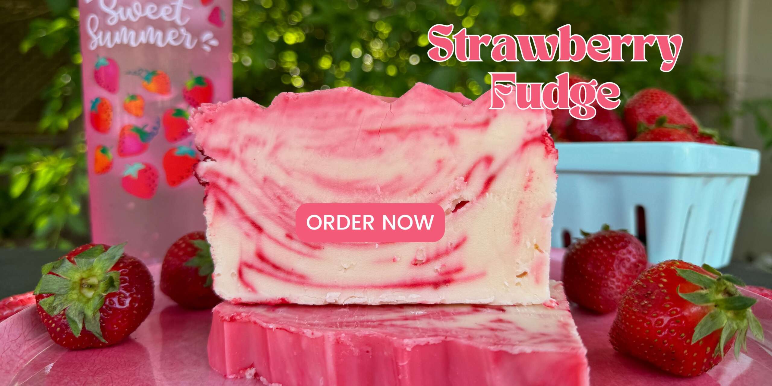 Strawberry fudge with a basket of strawberries in the back and loose strawberries